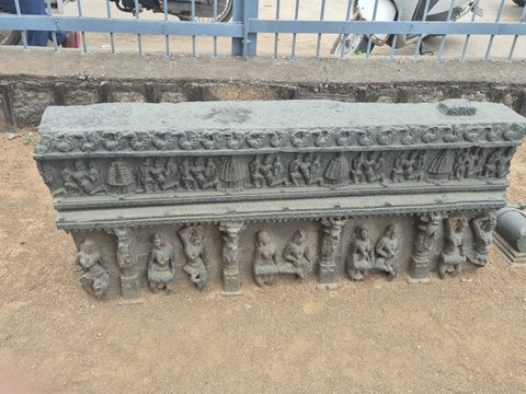 Another photograph of the same recorded subject. A long horizontal fragment carries a narrow upper frieze and a lower sequence of figures between carved supports. Its right edge extends beyond one photograph.