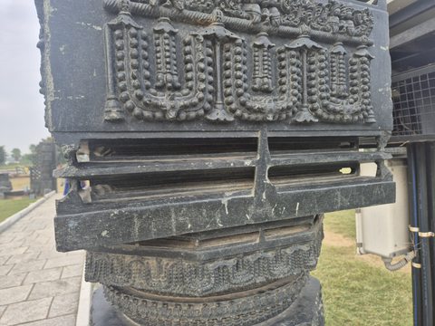 Three hanging garland forms decorate a rectangular face above stepped stone mouldings. A rounded carved section is visible below.