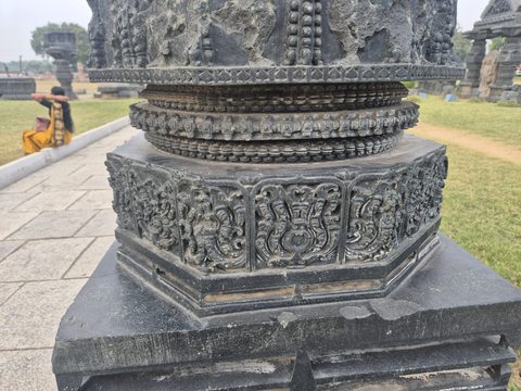 Floral panels encircle an angular lower section beneath narrow rounded bands. The photograph records only part of the column.