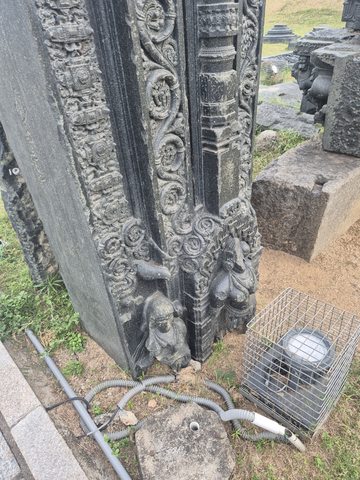 Parallel vertical bands combine small figures, curls and a narrow column-like element. The lower part is photographed beside modern lighting equipment.