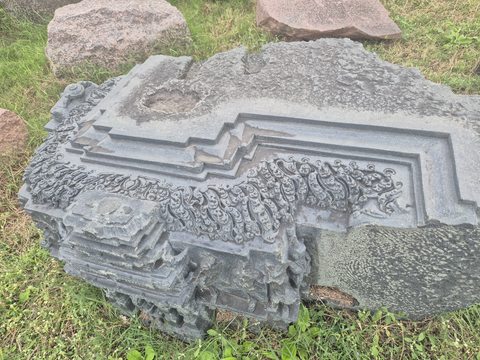 Fine scrolling ornament lies between sharply stepped borders. A broken corner reveals the thickness and irregular surviving edge of the piece.