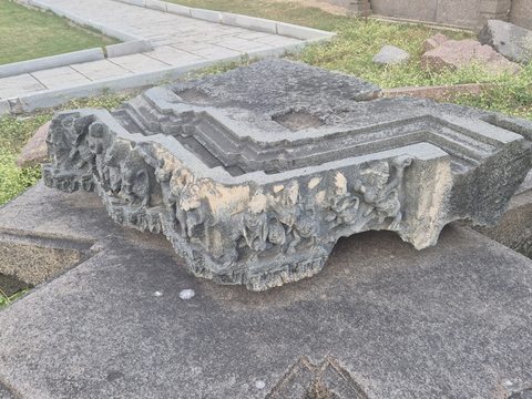 A deep corner piece combines stepped upper mouldings and projecting carved forms underneath. Broken edges remain visible on both sides.