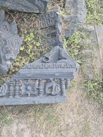 Small framed figures line the lower band of an irregular fragment. Part of a larger carved form survives above them.